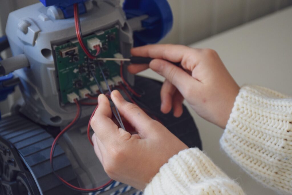 a child fixing and programming a toy robot